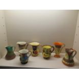 Seven decorative jugs including Wadeheath, Myott, Devon ware and Beswick, all have some crazing