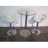 A glass top bar table, 91cm tall, with two moulded white seats gas lift stools, some usage marks but