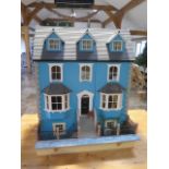 A large dolls house modelled on an Edwardian four floor house with furniture and accessories and