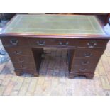 A mahogany effect twin pedestal eight drawer desk with an inset top, 79cm tall x 122cm x 61cm,