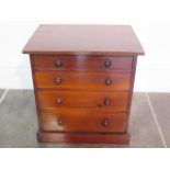 A Victorian miniature chest of drawers of collectors chest of four graduated drawers with turned