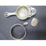 A silver enamel bangle by Topazio, a silver thimble, a silver strainer and a silver snuff box in the