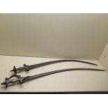 Two Indian Talwar swords, one with serrated blade, 93cm and 85cm long, both with pitting and some