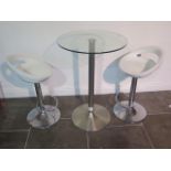 A glass top bar table, 91cm tall, with two moulded white seats gas lift stools, some usage marks but
