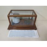 A Tycos barograph retailed by Harrods Ltd Opticians London, 36cm x 22cm x 19cm tall, with spare