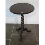 A Victorian mahogany tripod table, the circular top with raised lip above a barley twist stem and