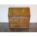 A George 1st walnut bureau with a well and stepped fitted interior above two small and two long