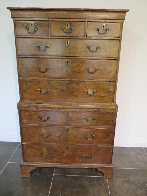 A George 1st walnut chest on chest with three small drawers, over a brushing slide and three further