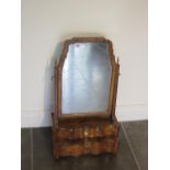 A George 1st walnut toilet mirror with a serpentine four drawer front on replacepment feet, 67cm