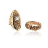 Two gold rings, one navette-shaped gold ring with carved decoration and centred with a circular-