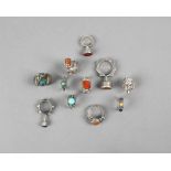 Ten Nubian rings silver coloured metal and set differing coloured glass, one engraved a star and