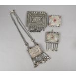A Bedouin hirz receptacle silver coloured metal with a cover and chain, 49cm long, and three hirz,