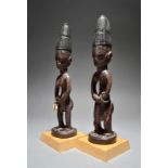 A pair of Yoruba Ibeji figures Nigeria male and female, with high conical coiffure, part decorated