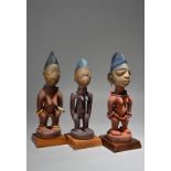 Three Yoruba Ibeji female figures Nigeria with washed faces, two with beads, 22.5cm and 24.5cm (