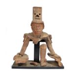 An Aztec fragmentary figure Mexico earthenware, with a head having a parted coiffure, a circle