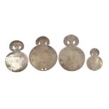 Four Colombian disc ornaments silver coloured metal, each with two attachment piercings and a