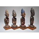 Four Yoruba Ibeji figures Nigeria including two males and two females, two with beads, 25.3cm, 25.