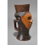 A Kuba palm wine cup Democratic Republic of the Congo with a carved head and a c shape handle,