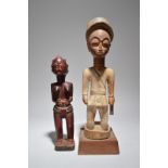 A Baule colon figure Ivory Coast of a uniformed officer, 41cm high, on a fixed base, and a Baule