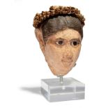 An Egyptian stucco painted head of a woman Roman Period, circa late 1st - early 2nd century AD