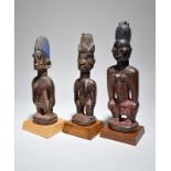 Three Yoruba Ibeji figures Nigeria including two females and one male, 25cm, 25.5cm and 29cm high,