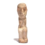 A South Arabian style seated figure carved stone with an inscription to the forehead, 36.5cm high.