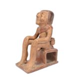 A Narino seated figure of a coca-chewer Colombia pottery, wearing a sash and a loin cloth with an