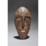 A Lega mask Democratic Republic of the Congo with circle and dot decoration, earth fill with
