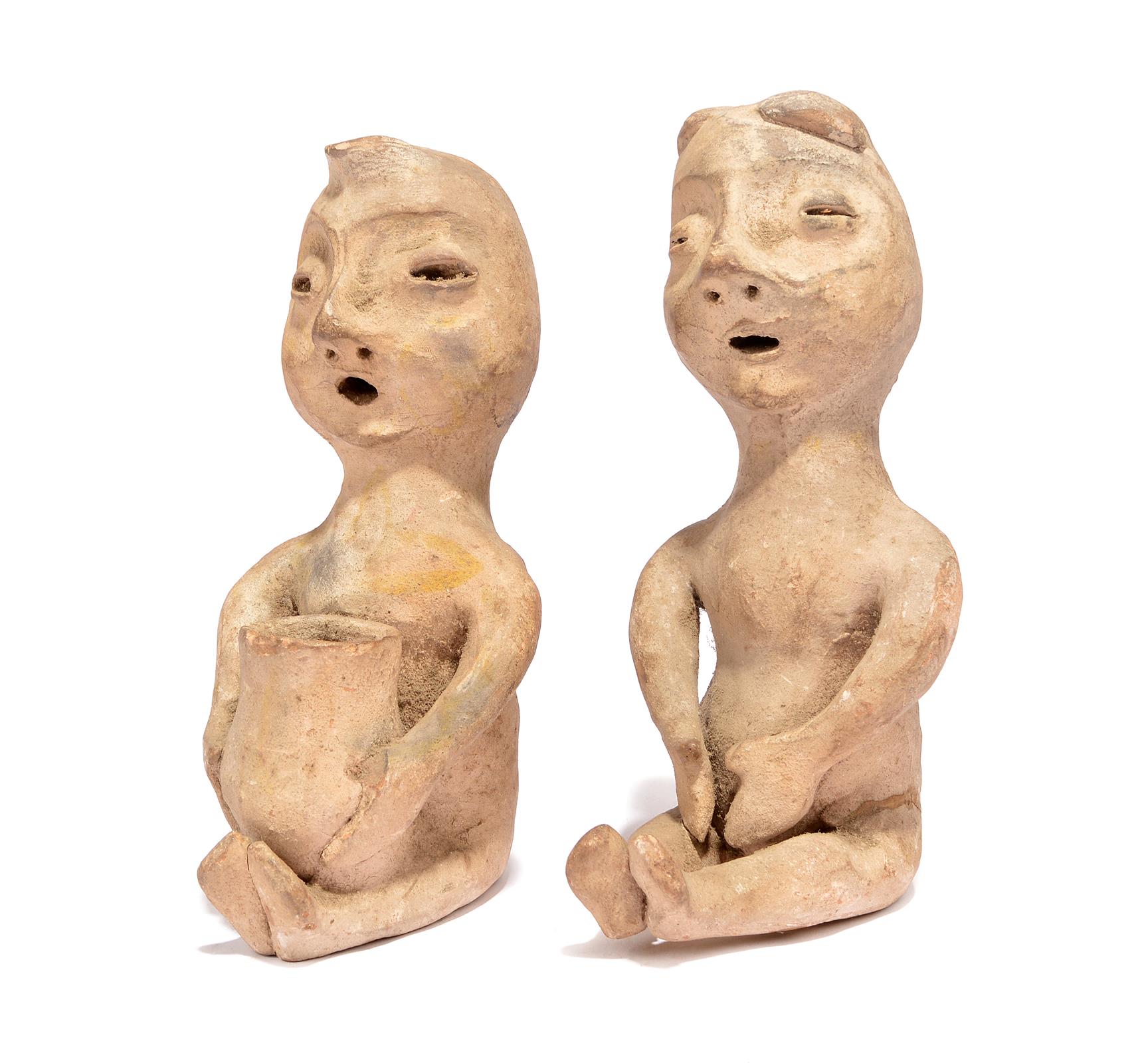 A pair of Pueblo seated rain god figures Southwestern North America earthenware, one holding a