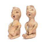 A pair of Pueblo seated rain god figures Southwestern North America earthenware, one holding a
