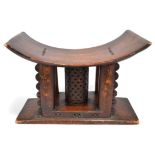 An Ashanti stool Ghana with a pierced central column support, 42cm high, 60.5cm long.