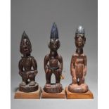 Three Yoruba Ibeji figures Nigeria two with beads and cowrie shells, 26cm, 28.5cm and 30cm high,