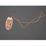 An Aboriginal pendant Kimberly, Western Australia shell with carved linear decoration and ochre