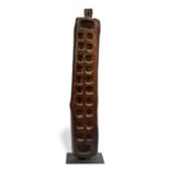 A Gurage game board gabet'a Ethiopia with twenty-two recesses, 120cm long, on a mounted base.