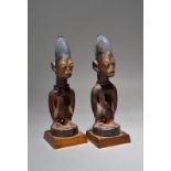 A pair of Yoruba Ibeji male figures Nigeria with bead necklaces, 26cm high, on fixed stands. (2)