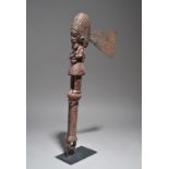 A Yoruba shango axe Nigeria with a carved standing figure and an iron blade, 52cm long, on a