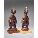 A matched pair Yoruba Ibeji male figures Nigeria with beads, 25.5cm and 26cm high, on fixed