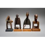 Four Senufo heddle pulleys Ivory Coast three with bird head finials and one with a firespitter mask,