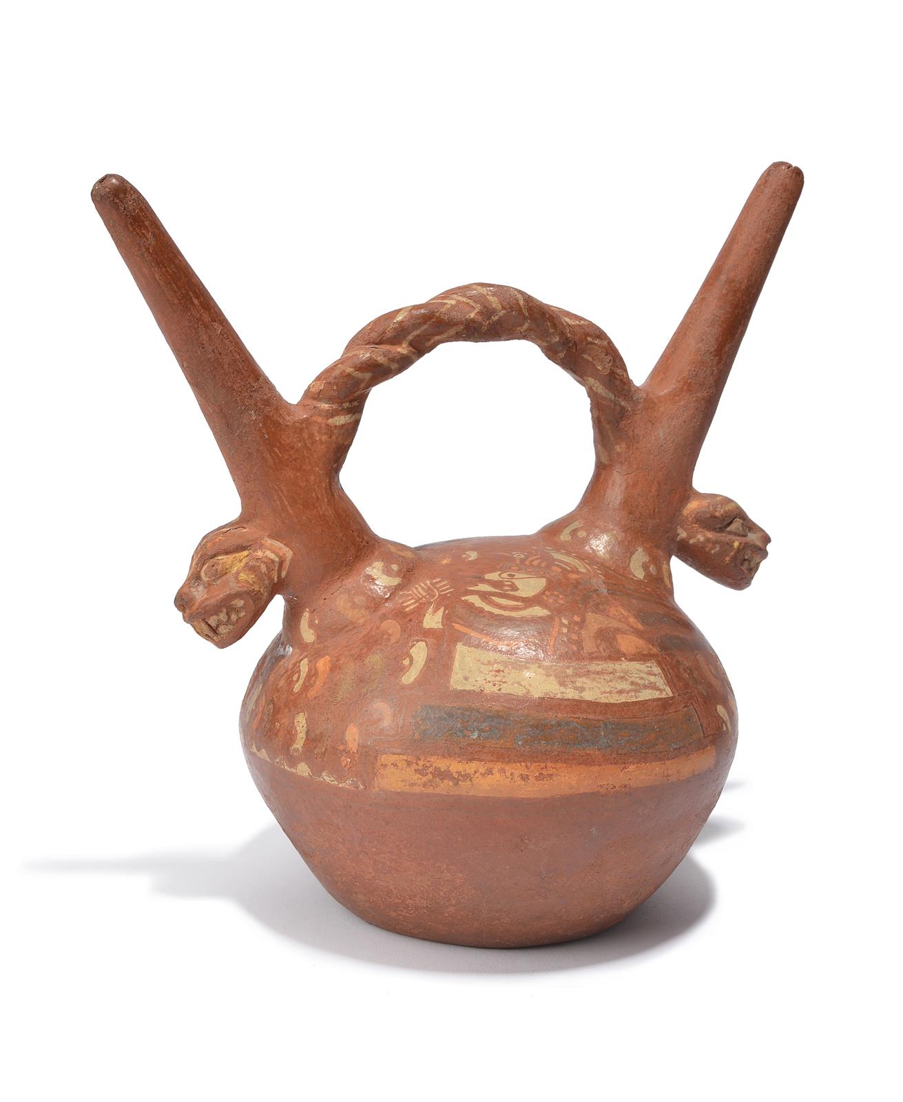 A Peru double spouted stirrup vessel terracotta, with stylised animal heads with barred teeth and