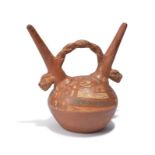A Peru double spouted stirrup vessel terracotta, with stylised animal heads with barred teeth and