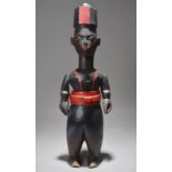 An Ibibio colon figure Nigeria of an officer, with articulated arms, painted black, red and brown,