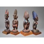 Four Yoruba Ibeji figures Nigeria including a male and three females, one with a bead necklace,