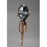 A Dan mask Ivory Coast with aluminium to the open eyes and mouth and with a linear outlined face and