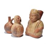 A Viru double chamber stirrup vessel Peru earthenware with a figure with pierced ears, eyes,