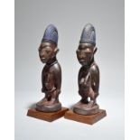 A pair of Yoruba Ibeji figures Nigeria male and female, with beads, 27.8cm and 28.4cm high, on fixed