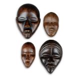 Four Dan passport masks Ivory Coast three with pierced eyes and one with a pierced mouth, 10cm,10.