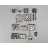 Thirteen Nubian / Bedouin amulets silver coloured metal, with applied decoration, the widest 6.