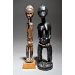 A Baule standing female figure Ivory Coast with raised facial, neck and abdomen scarifications,