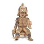 A Veracruz seated warrior Mexico, circa 600 - 900 AD pottery, wearing a mask helmet, a face mask and