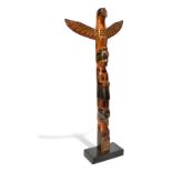 An Alert Bay model totem pole by Arthur Gordon Shaughnessy, carved wood with a raven, a standing